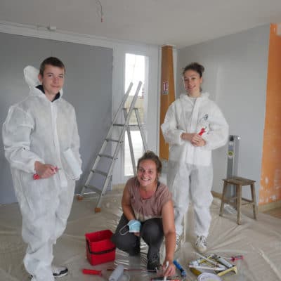 Trois jeunes sur un chantier de peinture.