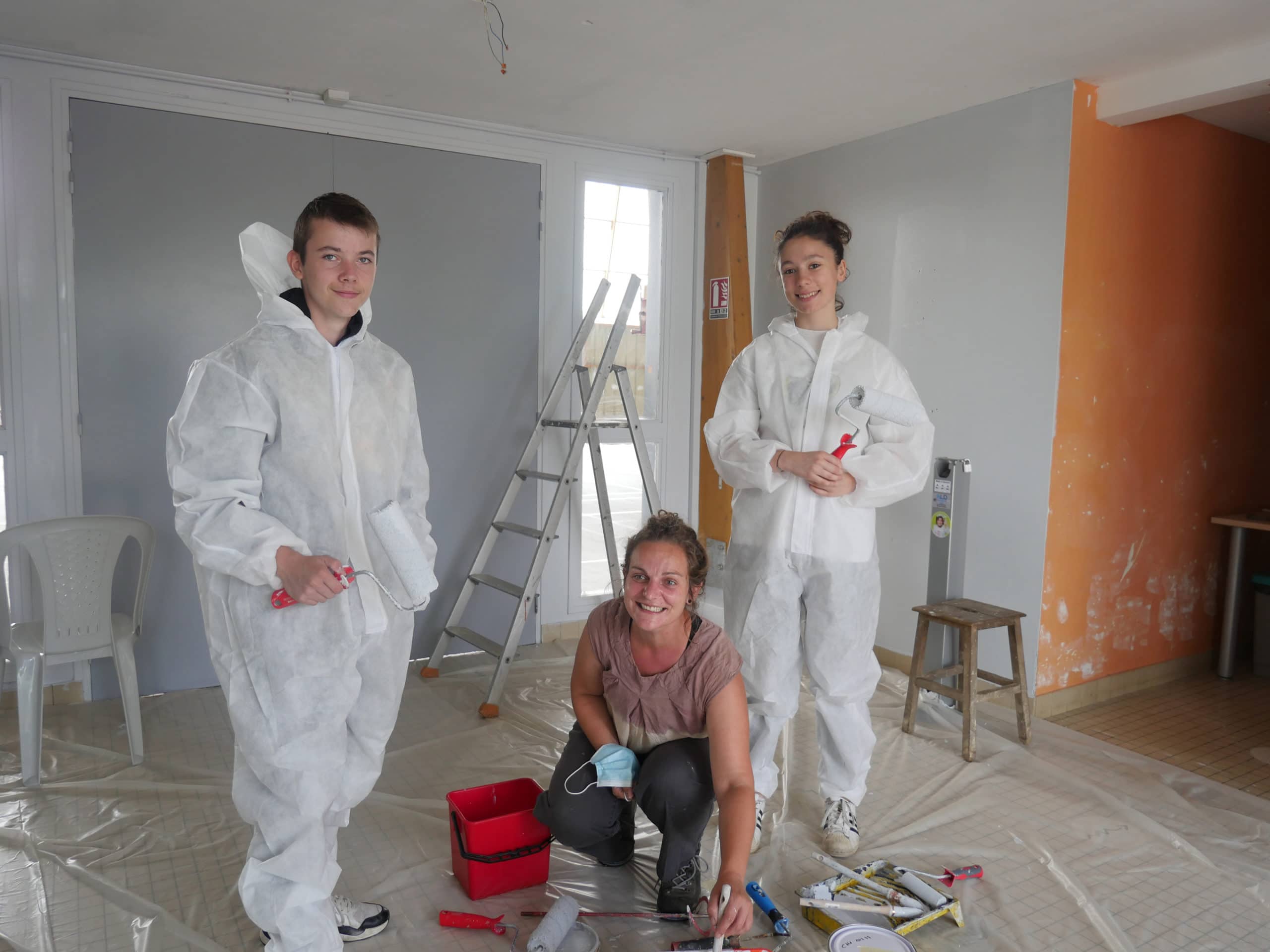 Trois jeunes sur un chantier de peinture.