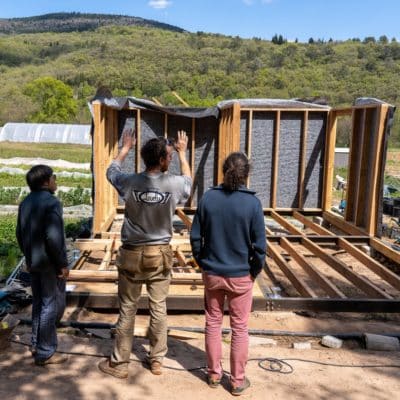 © Bastien Defives. Pose ossatures murs (extérieurs et intérieurs) et ossatures toiture. Projet BatiAlim. Formation à l'autoconstruction agricole donnée par 3PCo. Sur la parcelle du Jardin de Campeyrou. Avec l'aide du collectif Résilience alimentaire de Lodève. Campeyrou, Lodève. Hérault.